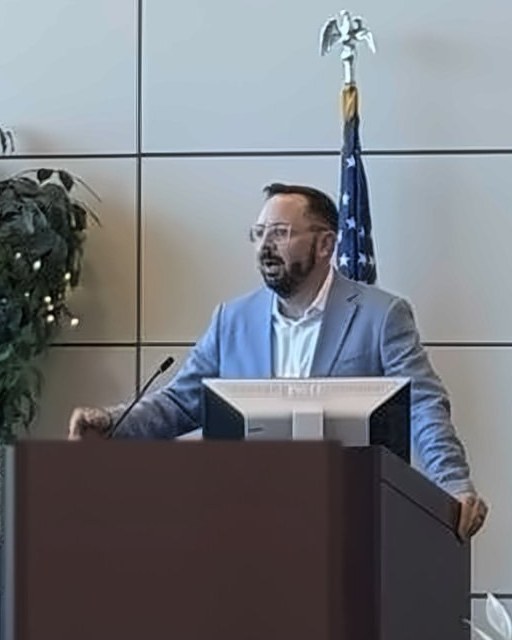 David Wible speaking at a podium